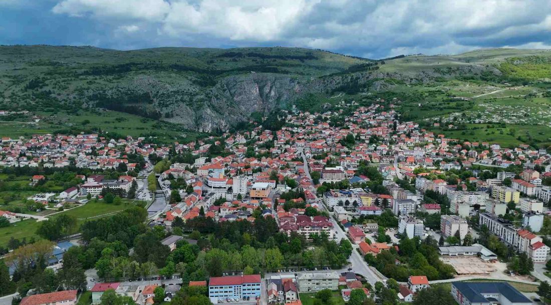 Pogled iz zraka na Livno, gradske četvrti i okolna brda.