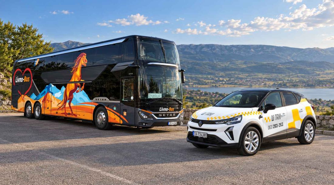 Livno-Bus autobus i bijelo Li Taxi vozilo na vidikovcu s pogledom na planinski krajolik.