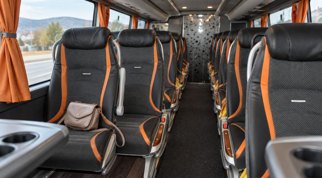 Ženska torbica ostavljena na sjedalu autobusa Livno-Busa s crno-narančastim presvlakama.