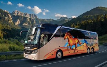 Livno-Bus autobus vozi planinskom cestom kroz prirodni krajolik.