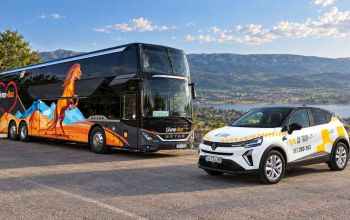 Livno-Bus autobus i bijelo Li Taxi vozilo na vidikovcu s pogledom na planinski krajolik.