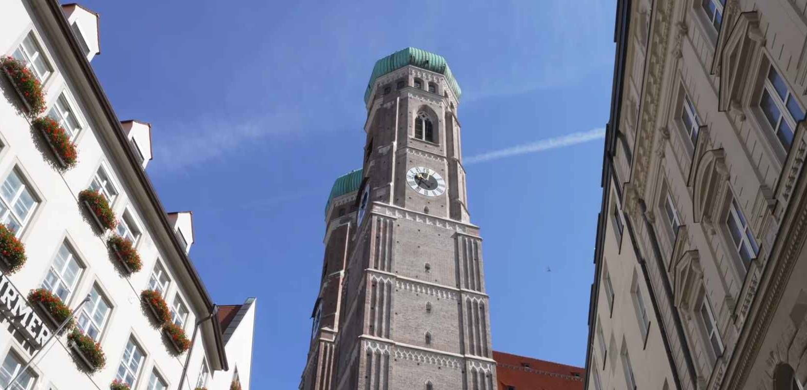 Pogled na tornjeve Frauenkirche katedrale između gradskih zgrada u Münchenu.