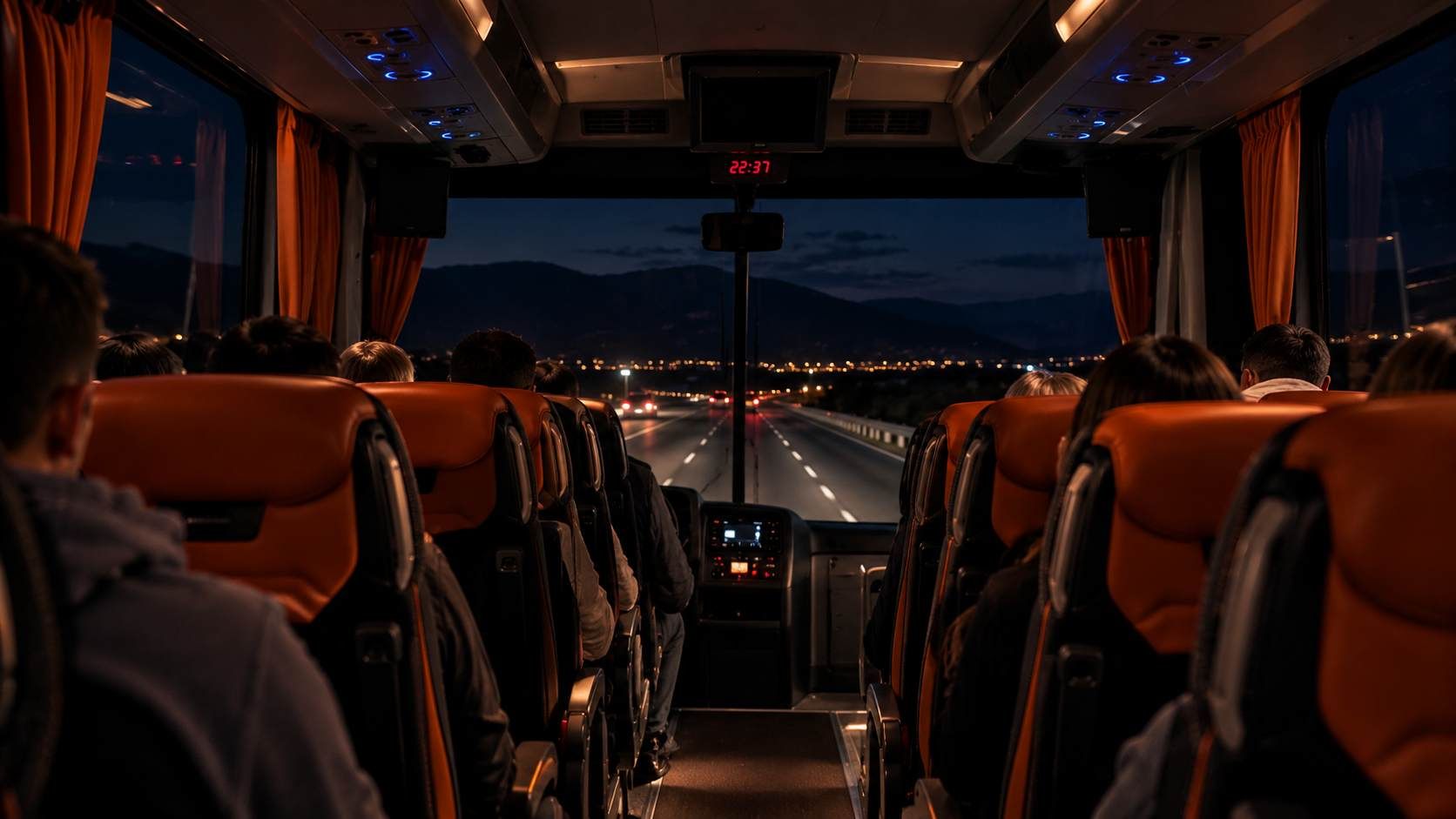 Noćna vožnja Livno Busom s pogledom na osvijetljenu cestu kroz prednje staklo autobusa.