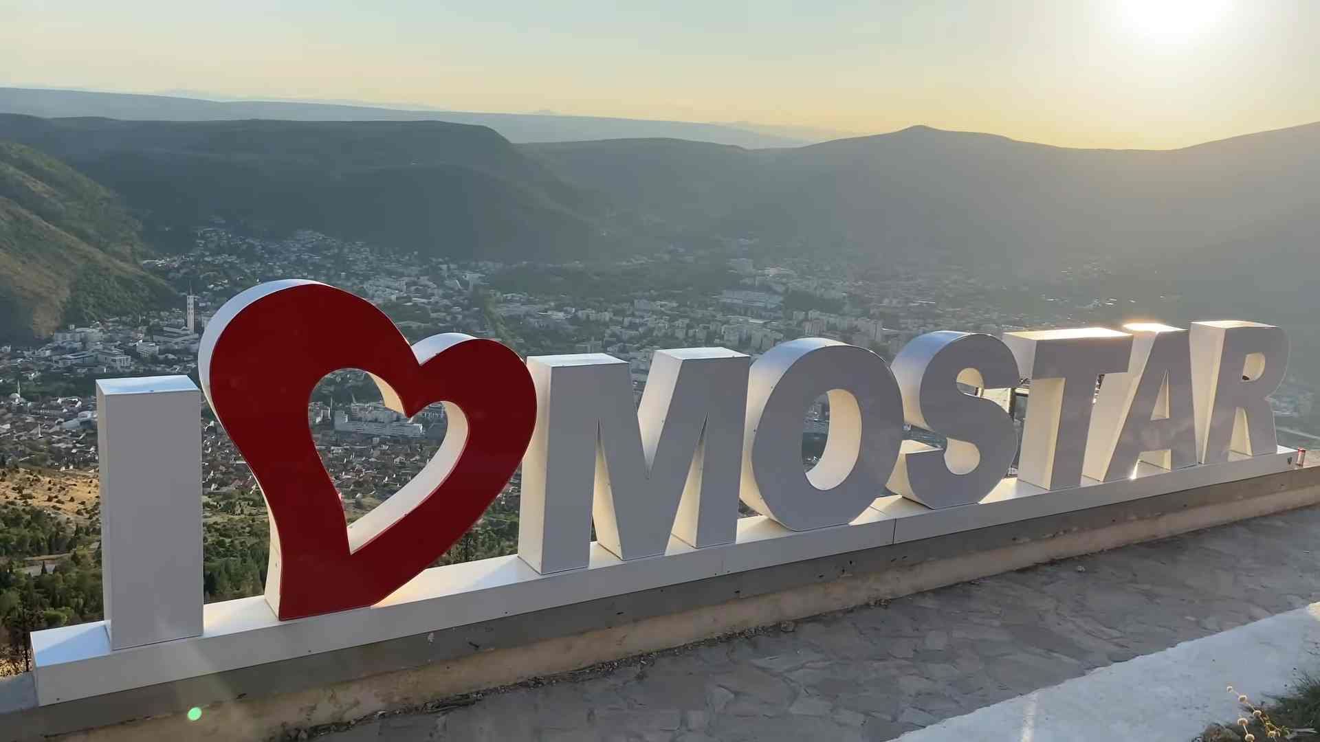 Natpis I Love Mostar na vidikovcu s panoramskim pogledom na grad.