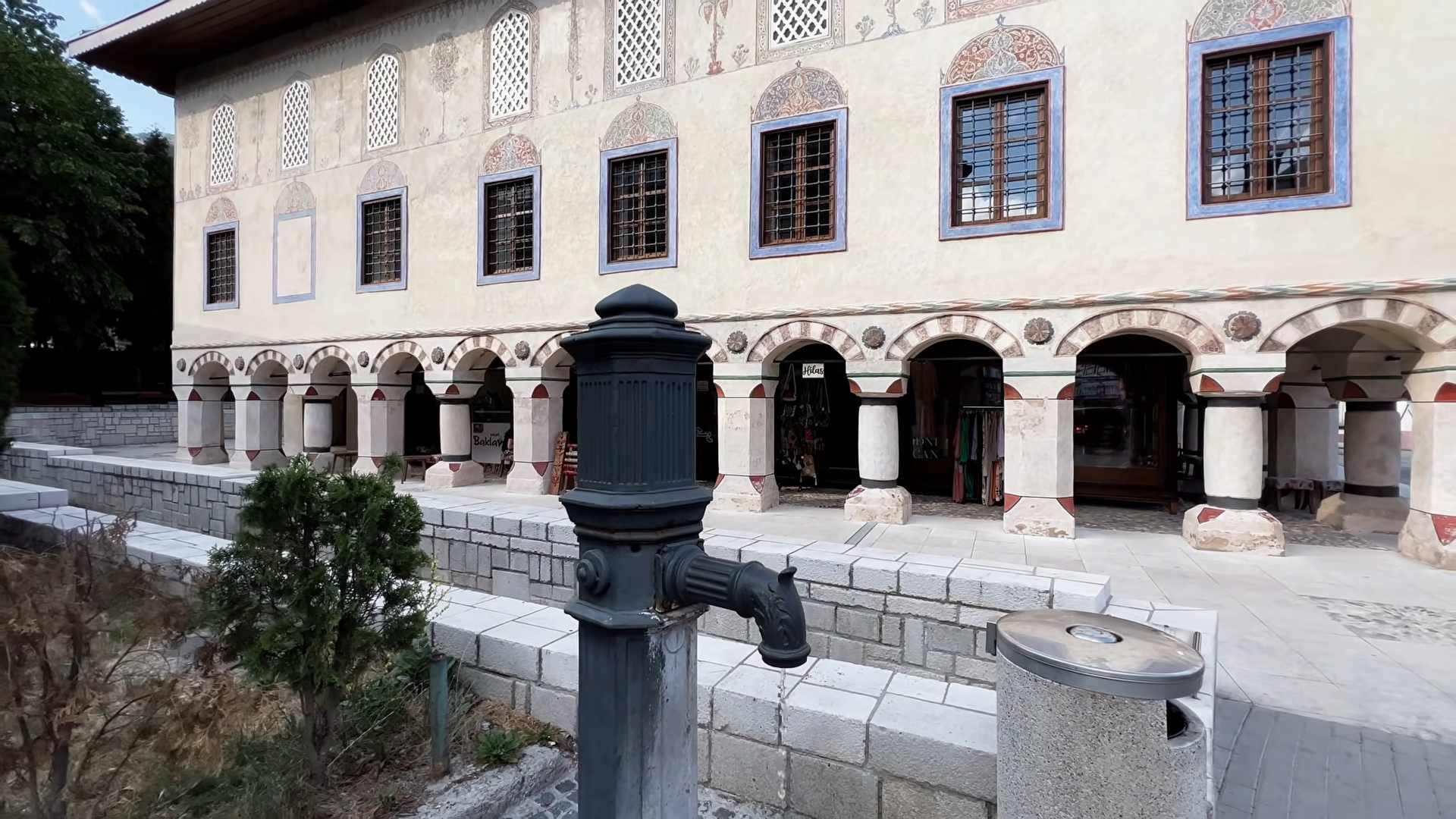 Šarena džamija Sulejmanija u Travniku s ukrašenim pročeljem, kamenim lukovima i javnom česmom.