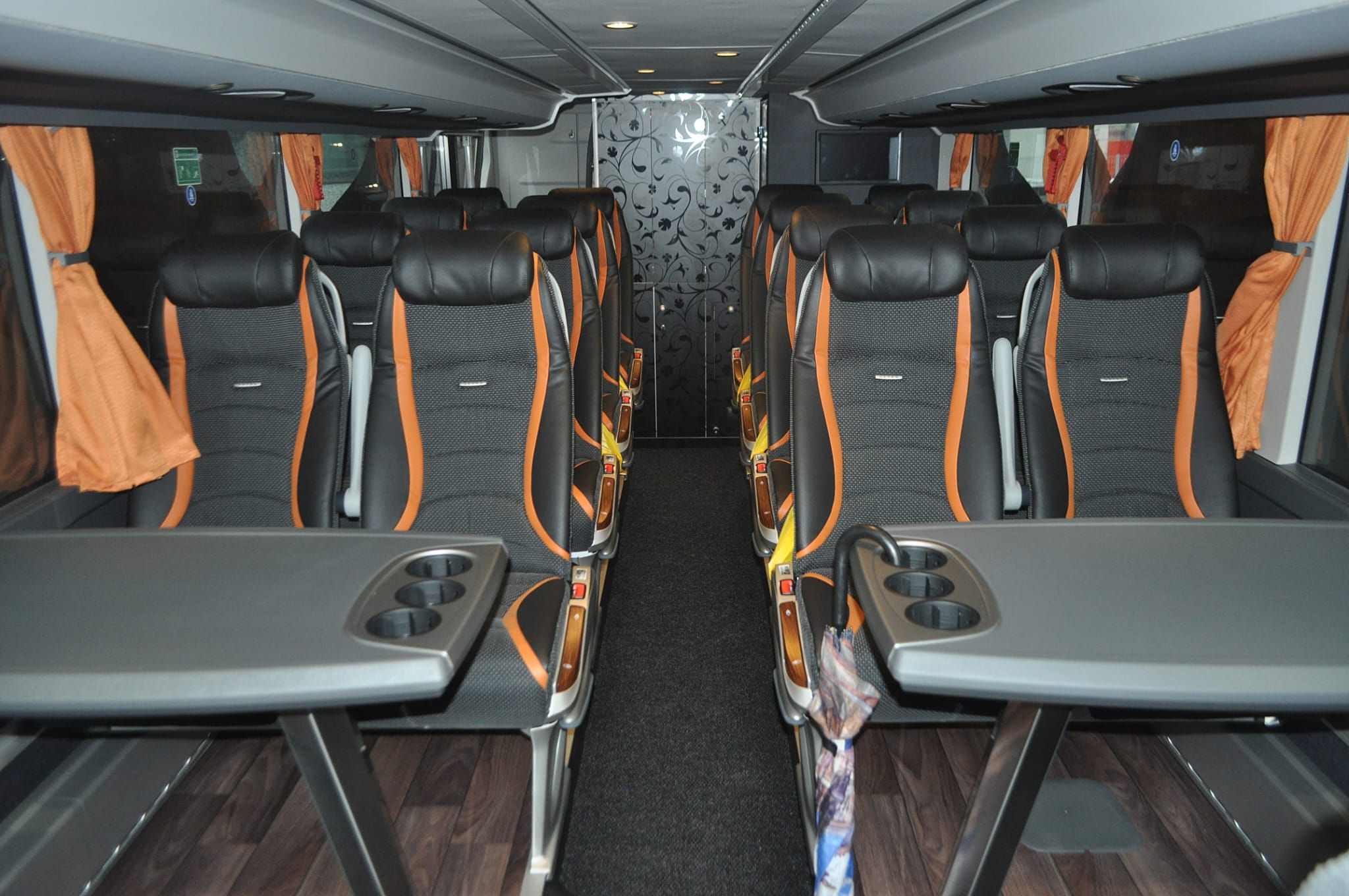 Unutrašnjost autobusa s udobnim sjedalima i stolovima za putnike.